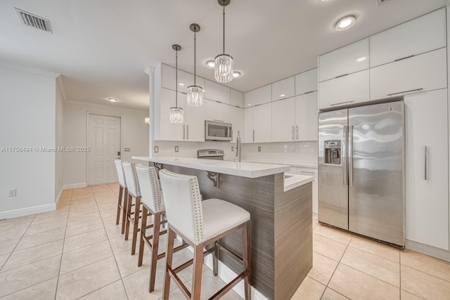 kitchen with a breakfast bar, light tile patterned floors, light countertops, visible vents, and appliances with stainless steel finishes