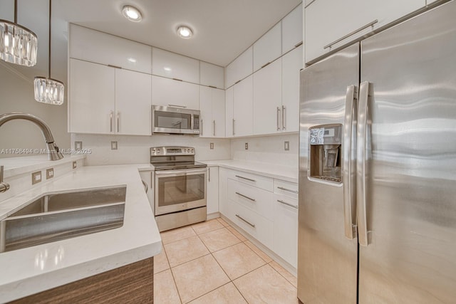 kitchen featuring light tile patterned floors, stainless steel appliances, a sink, and light countertops