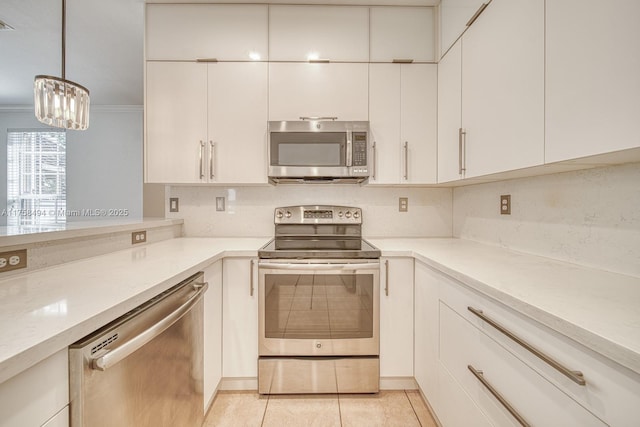 kitchen featuring light tile patterned floors, tasteful backsplash, light countertops, appliances with stainless steel finishes, and white cabinets