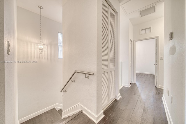 hall featuring dark wood-style flooring, visible vents, and baseboards