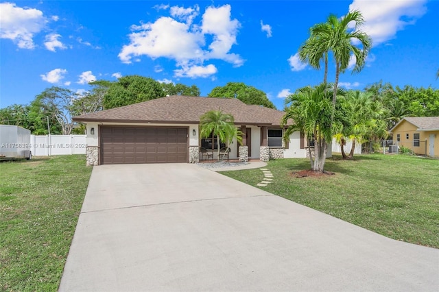 ranch-style house featuring a garage, driveway, fence, and a front lawn