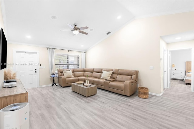 living room featuring lofted ceiling, light wood-style flooring, visible vents, baseboards, and ornamental molding