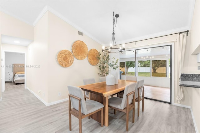 dining room with baseboards, visible vents, lofted ceiling, light wood-style flooring, and crown molding