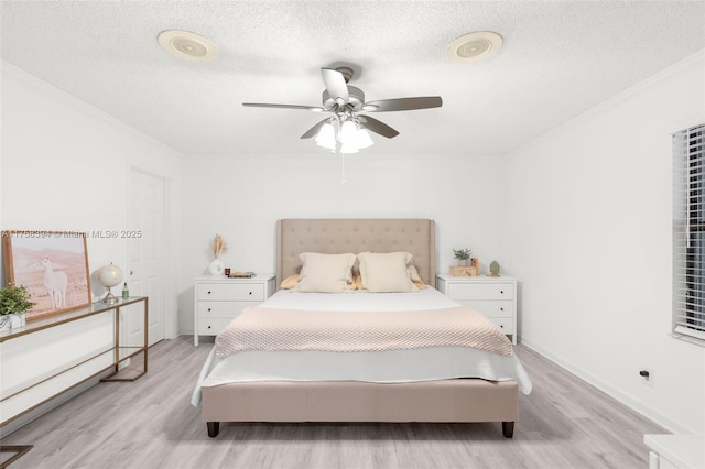 bedroom featuring light wood-style flooring, crown molding, ceiling fan, and a textured ceiling