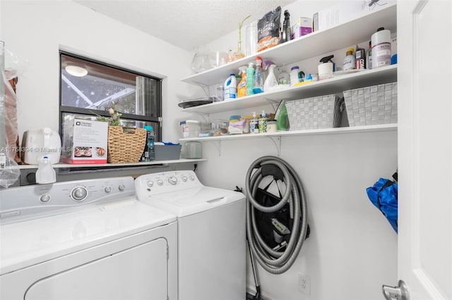 laundry area with washing machine and dryer, laundry area, and a textured ceiling