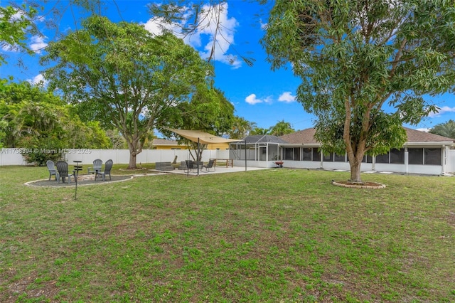 view of yard featuring a sunroom, an outdoor fire pit, a patio area, and a fenced backyard