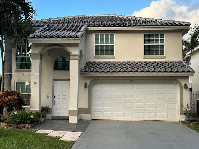 townhome / multi-family property featuring concrete driveway, a tile roof, and stucco siding