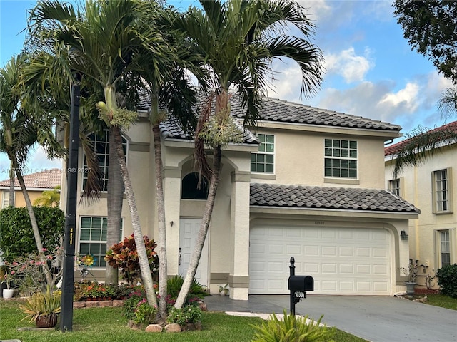 view of front of home with a garage, driveway, a tile roof, and stucco siding