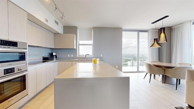 kitchen with expansive windows, light countertops, modern cabinets, and black electric cooktop