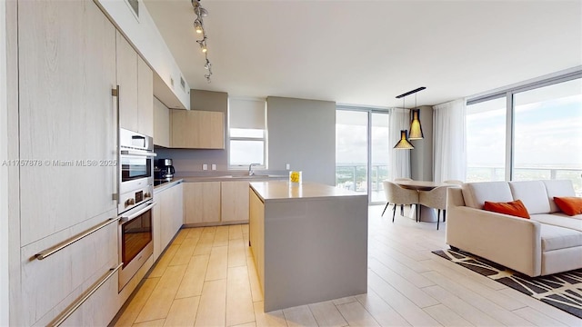 kitchen featuring a kitchen island, oven, a sink, and modern cabinets