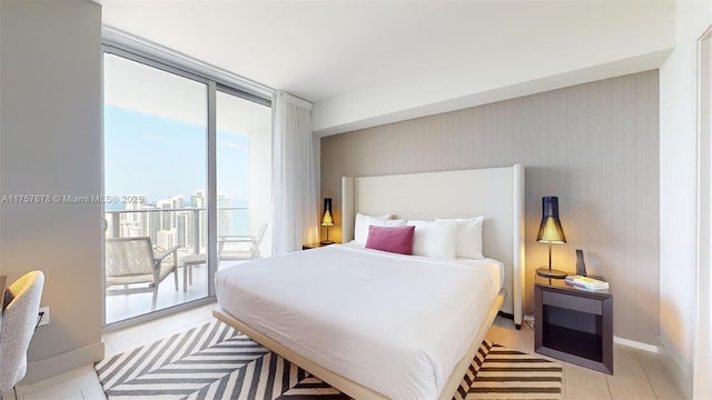 bedroom with a wall of windows, access to outside, and baseboards