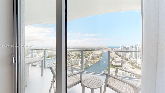 balcony featuring a water view and a city view