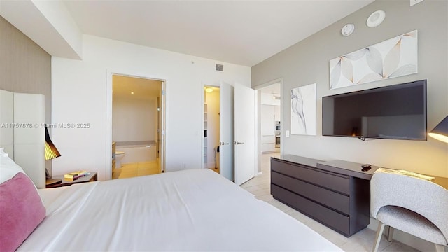 bedroom featuring light tile patterned flooring, ensuite bath, and visible vents