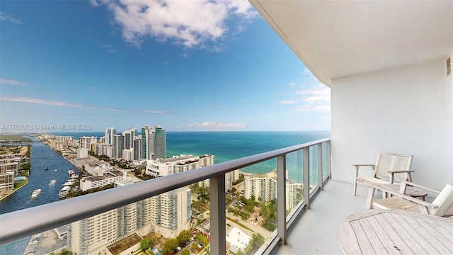 balcony featuring a water view and a city view