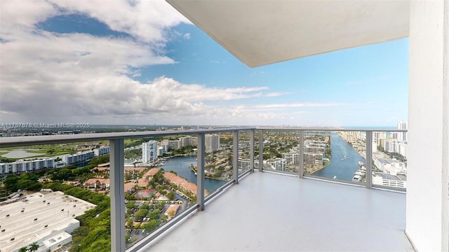 balcony featuring a water view and a city view