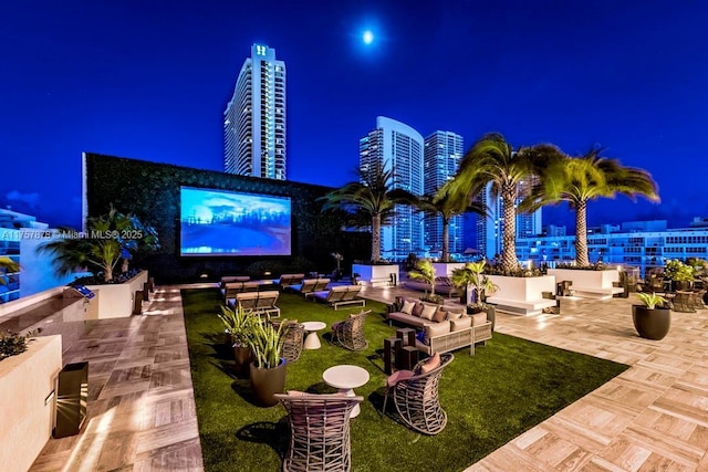 patio at twilight featuring outdoor lounge area and a view of city lights