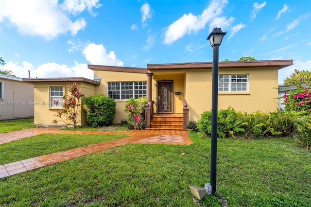 single story home with a front lawn and stucco siding