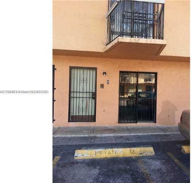 property entrance featuring stucco siding and a balcony