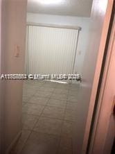 full bathroom featuring a tile shower and tile patterned flooring