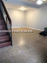 interior space with stairs, baseboards, and tile patterned flooring