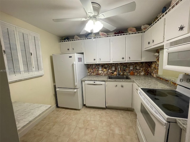 kitchen with tasteful backsplash, white appliances, white cabinets, and a sink