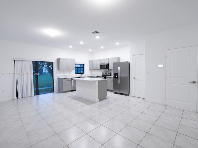 kitchen with recessed lighting, gray cabinetry, visible vents, appliances with stainless steel finishes, and a center island