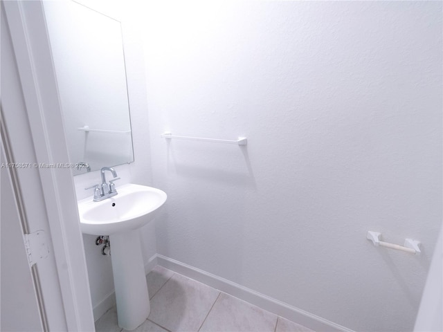 bathroom with baseboards and tile patterned floors