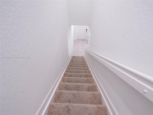 staircase featuring a textured wall