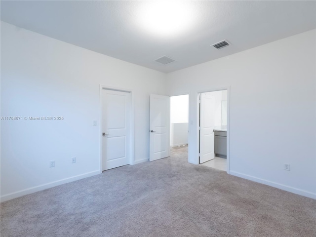 unfurnished bedroom featuring light carpet, baseboards, and visible vents