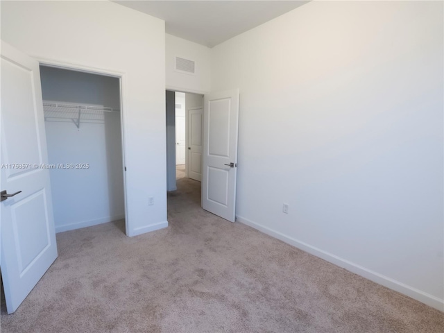 unfurnished bedroom featuring a closet, carpet flooring, visible vents, and baseboards