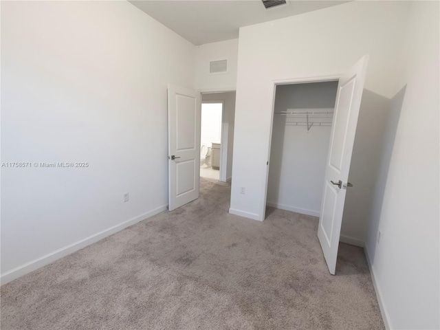 unfurnished bedroom featuring carpet floors, baseboards, visible vents, and a closet