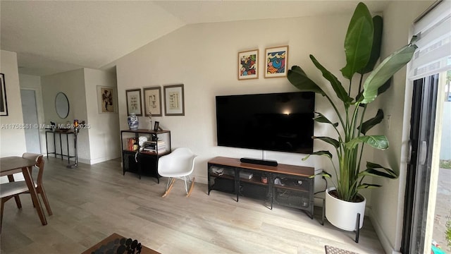 living room with lofted ceiling, baseboards, and wood finished floors