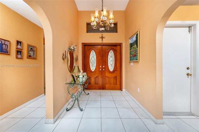 tiled foyer featuring arched walkways and baseboards