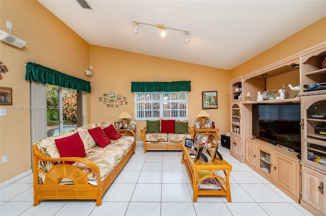 living area featuring lofted ceiling, visible vents, a wealth of natural light, and light tile patterned flooring