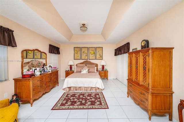 bedroom featuring a tray ceiling and light tile patterned floors