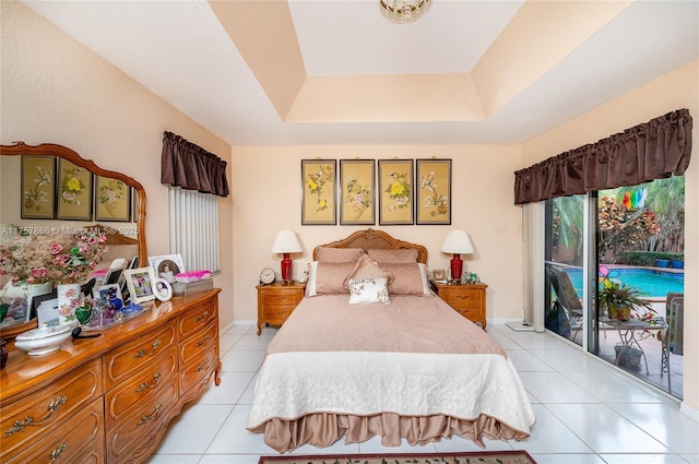 bedroom featuring access to outside, light tile patterned flooring, and a tray ceiling