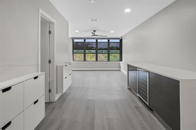 hallway with baseboards, light wood-type flooring, visible vents, and recessed lighting