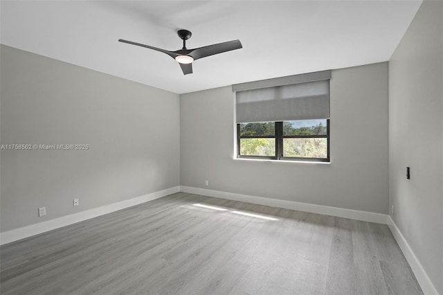 spare room with a ceiling fan, baseboards, and wood finished floors