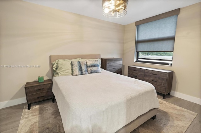 bedroom featuring wood finished floors and baseboards