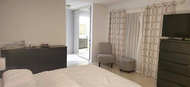 bedroom featuring light tile patterned flooring, floor to ceiling windows, and a closet