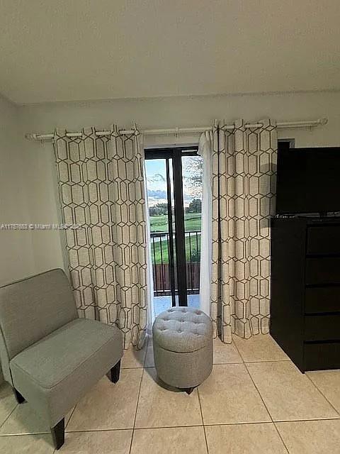 sitting room with light tile patterned floors and a textured ceiling