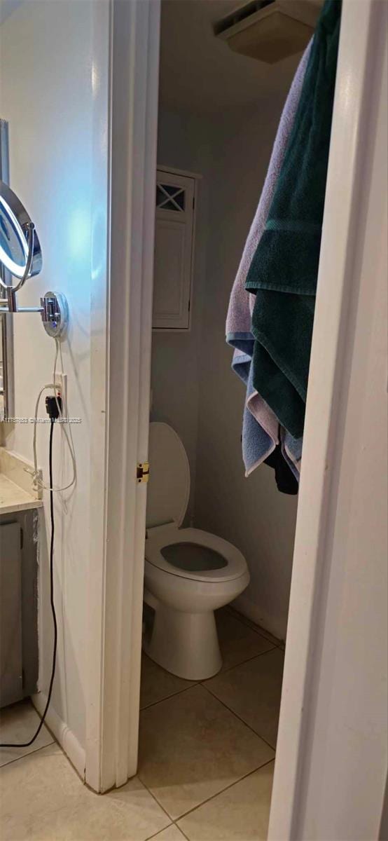 bathroom featuring tile patterned flooring, toilet, and vanity