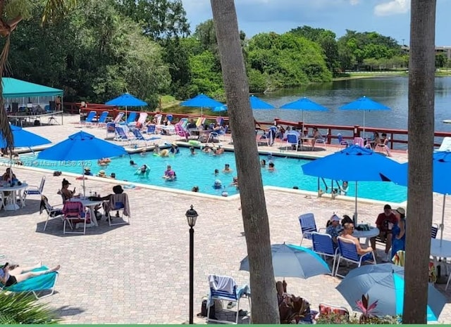 view of swimming pool featuring a patio area and a water view