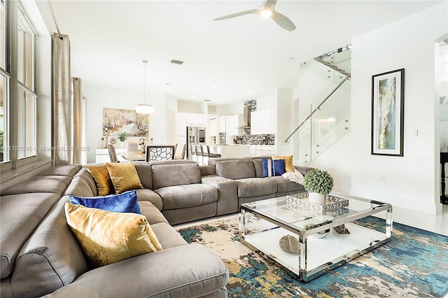 living area with ceiling fan and baseboards