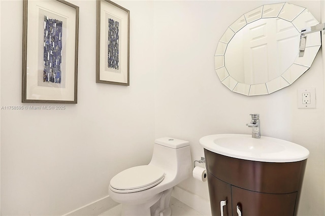 bathroom with vanity, toilet, and baseboards