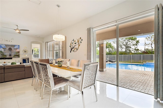 dining area with a ceiling fan, arched walkways, and light tile patterned floors