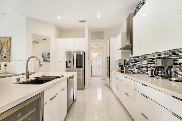 kitchen with beverage cooler, visible vents, modern cabinets, stainless steel appliances, and a sink