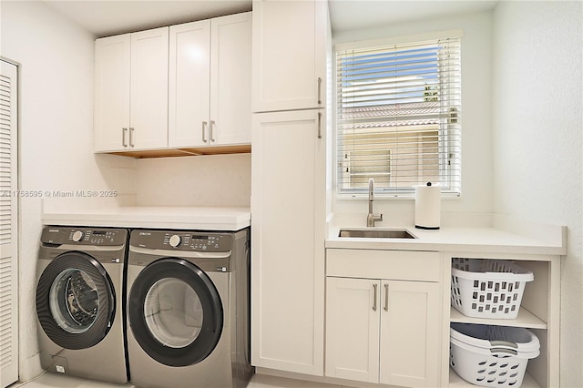 laundry area featuring independent washer and dryer, cabinet space, and a sink