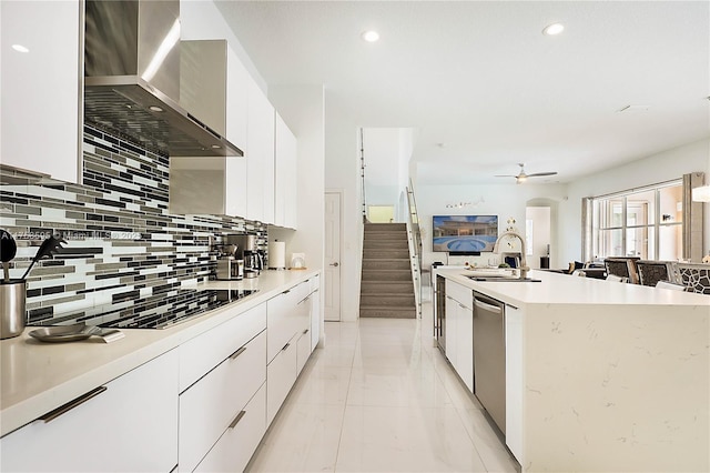 kitchen featuring white cabinets, a sink, wall chimney exhaust hood, and modern cabinets