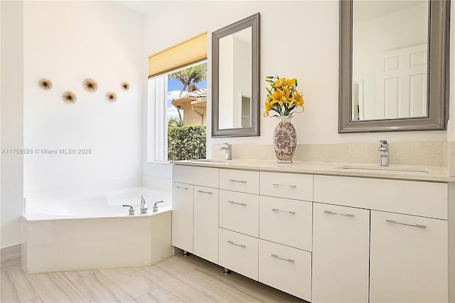 full bathroom featuring double vanity, a garden tub, and a sink